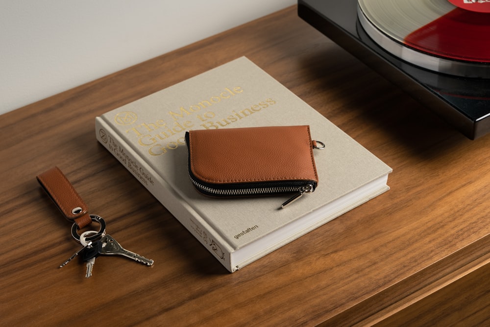 a brown wallet sitting on top of a wooden table next to a record player