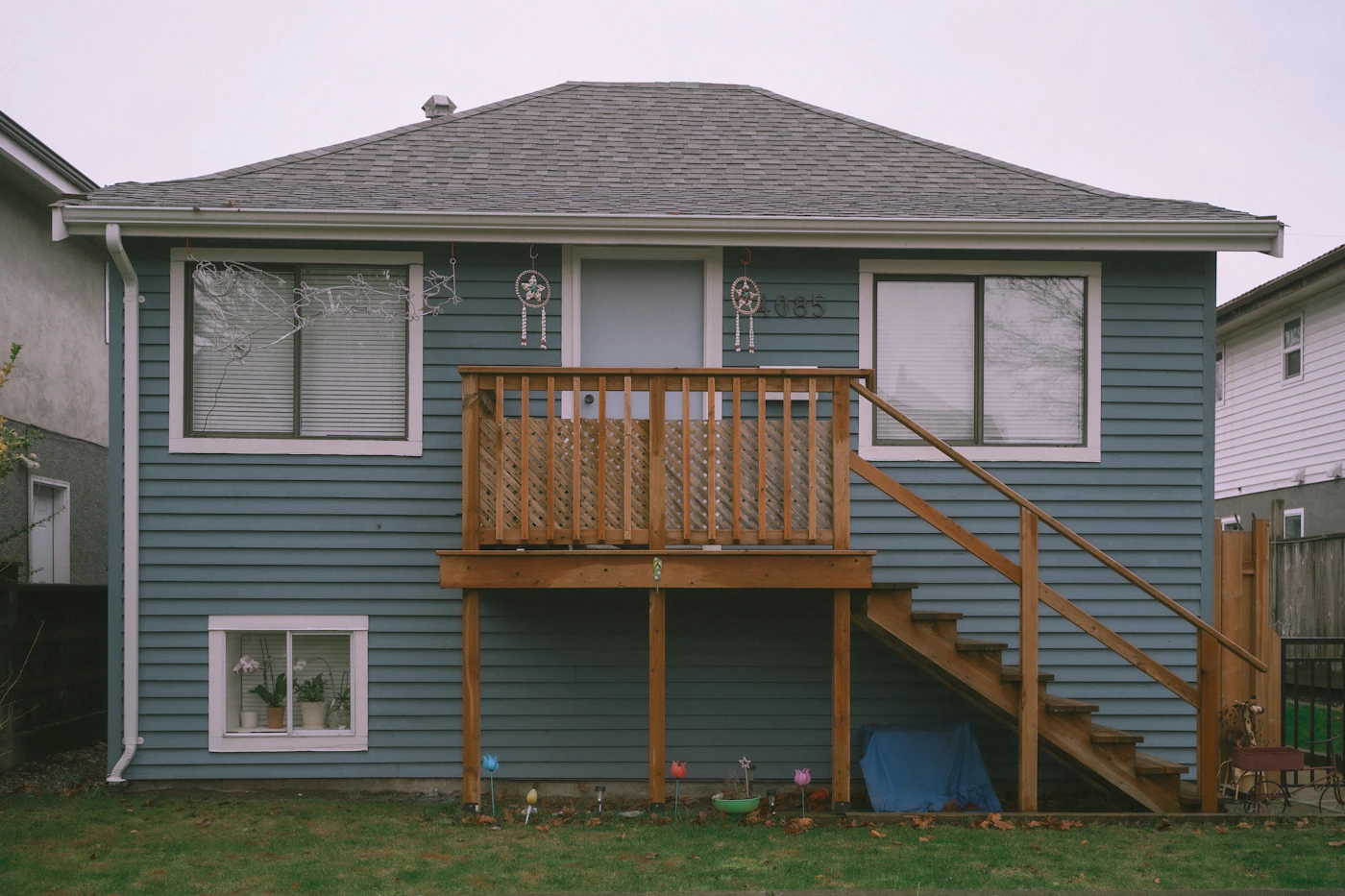 Blue house with upper deck and walkout lower level on a sloped lot