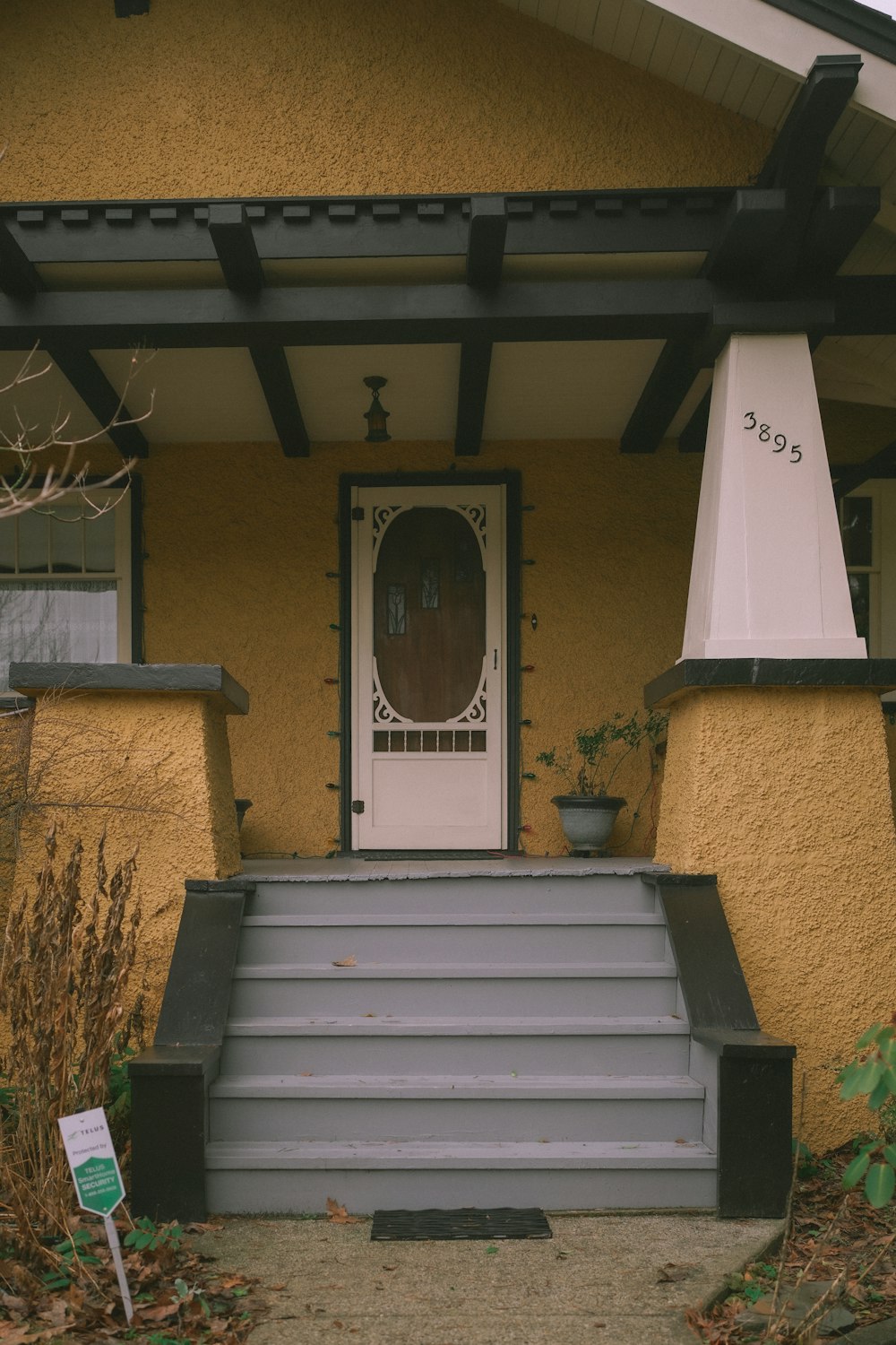 a yellow house with a white door and steps