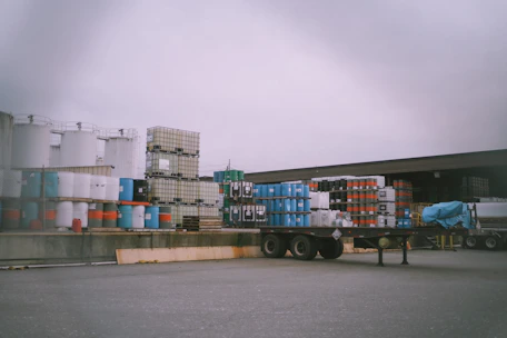 Industrial chemical containers being loaded for delivery in a warehouse.