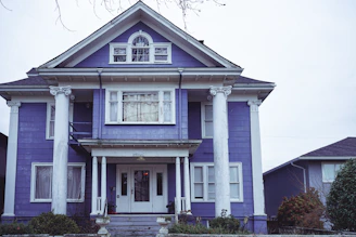 A dramatic exterior transformation featuring deep royal purple accents and silver-trimmed patio covers.