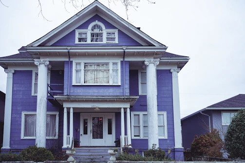 A dramatic exterior transformation featuring deep royal purple accents and silver-trimmed patio covers.