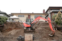 An inspector carefully examining a home's foundation with professional tools.