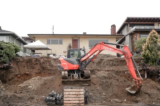 Technician inspecting a home's foundation with specialized equipment in a sunny residential neighborhood.