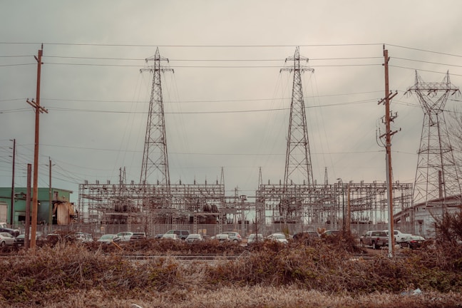 Technicians installing power cables along an industrial site corridor.