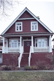 a red brick house with a white porch