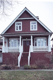 a red brick house with a white porch