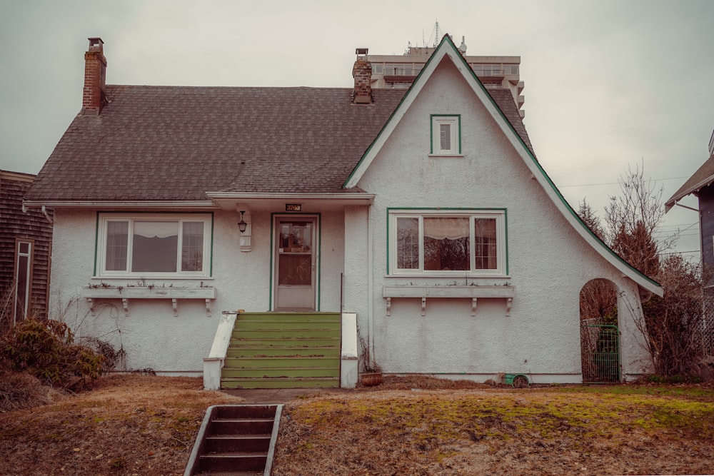 a small white house with a green door