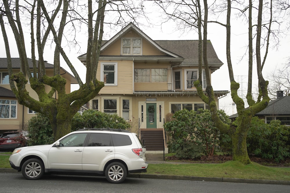 a white car parked in front of a house