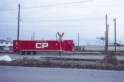 a red train car sitting on the side of a road