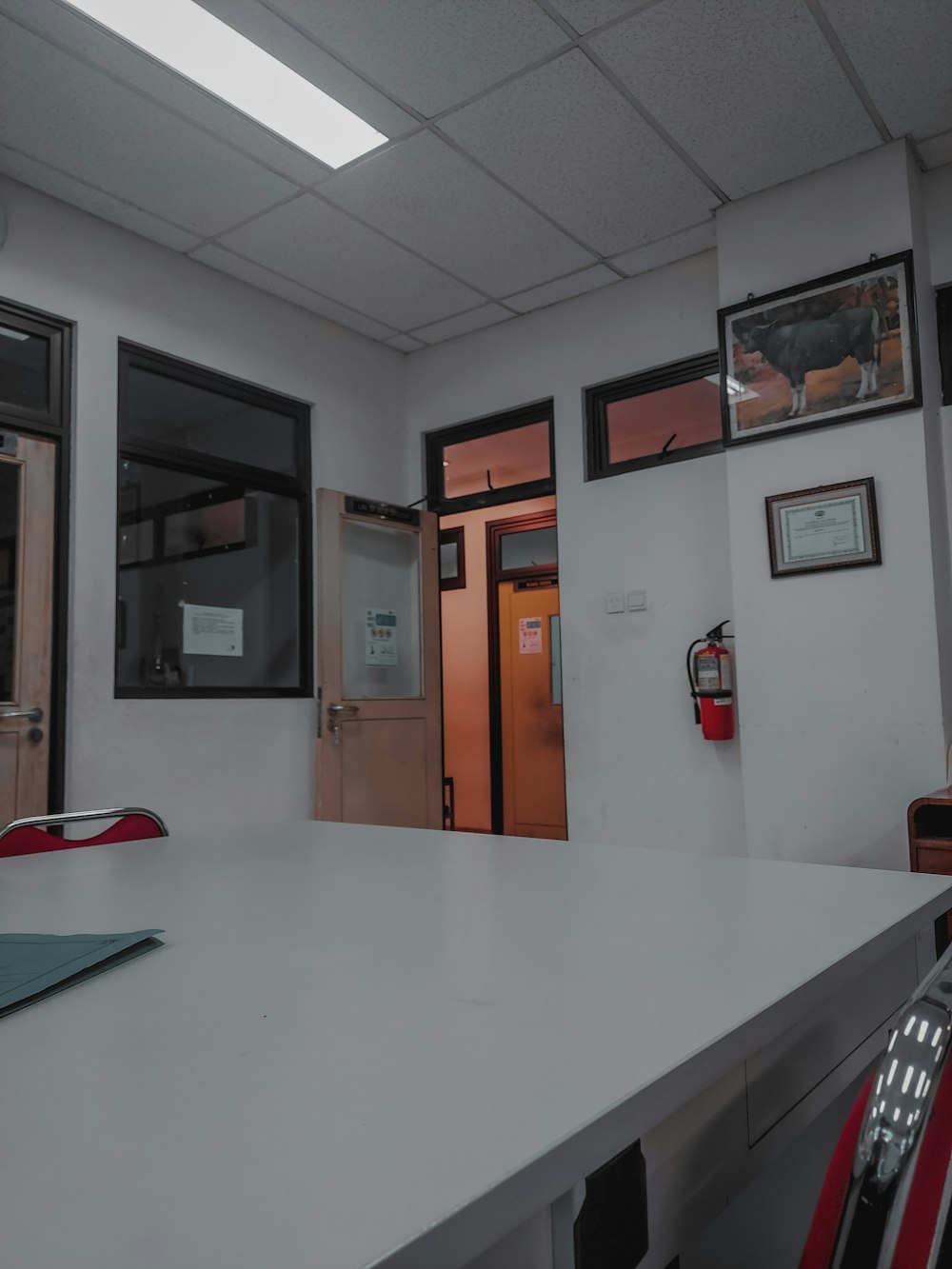 a room with a white table and a red chair