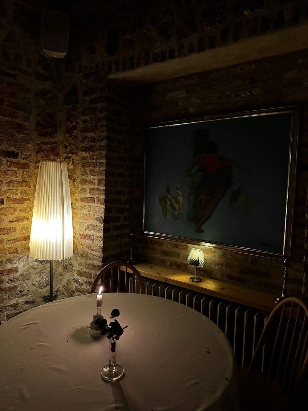 a table with a candle on it in a room with brick walls