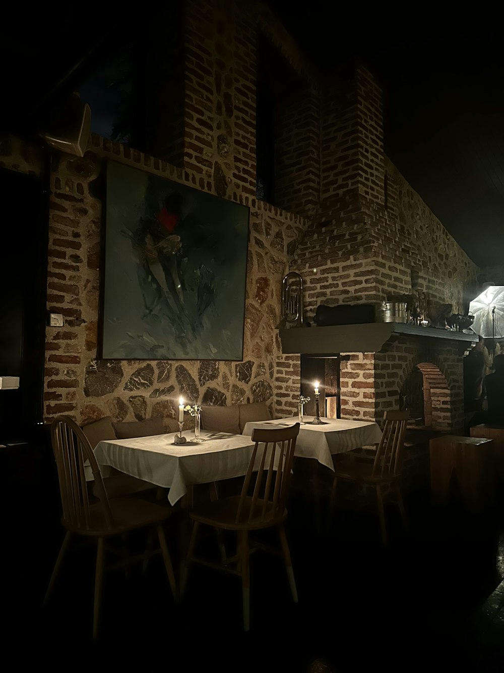 a dimly lit restaurant with a painting on the wall