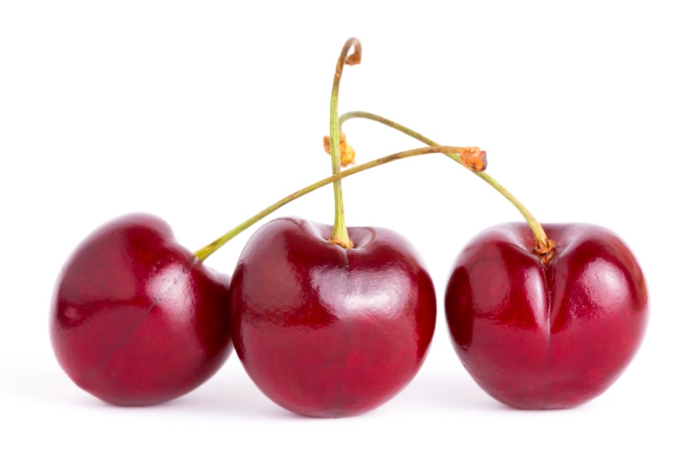 three cherries are shown on a white background
