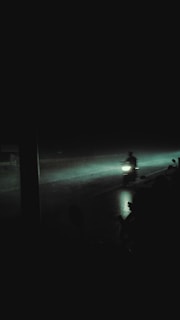 A lone rider speeding through a rain-soaked cyberpunk highway, headphones on, immersed in industrial bass.