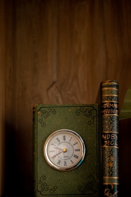Robert Greene's 'The 48 Laws of Power' book displayed with a vintage clock and reading glasses.