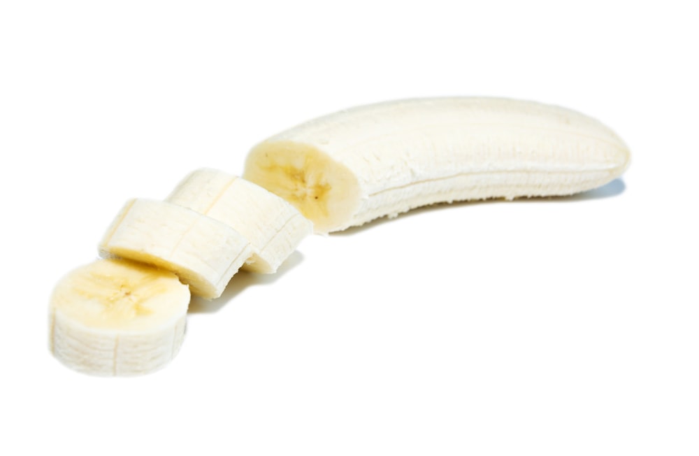 a half peeled banana sitting on top of a white surface