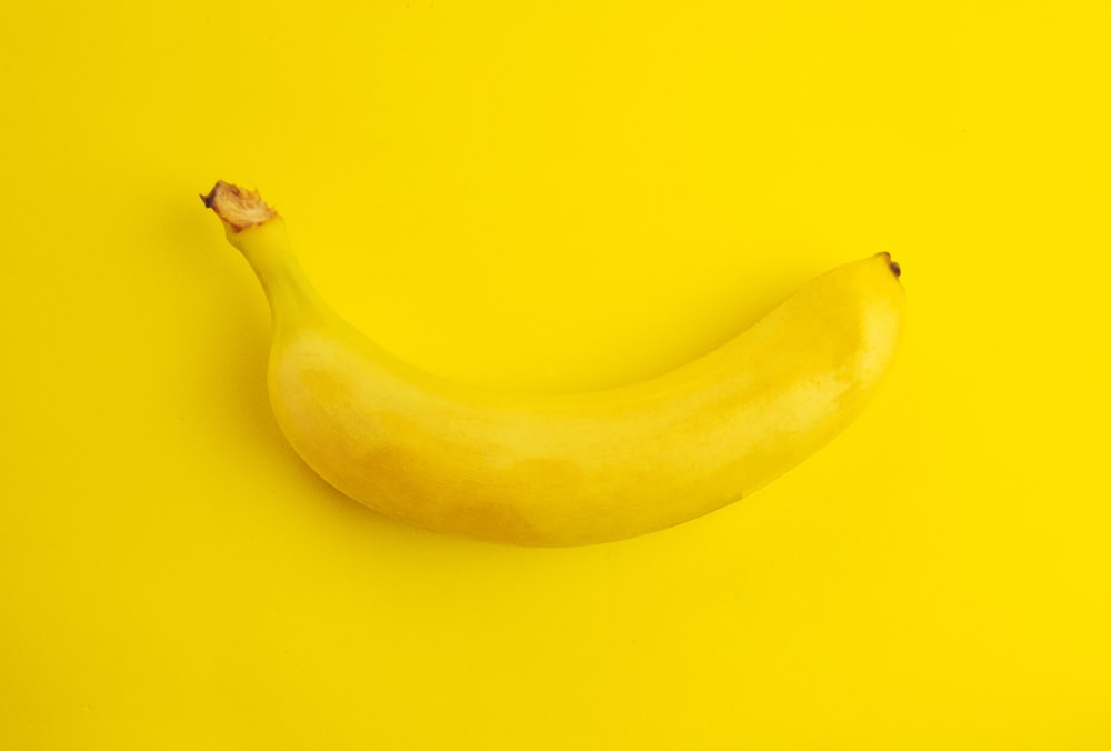 a yellow banana on a yellow background