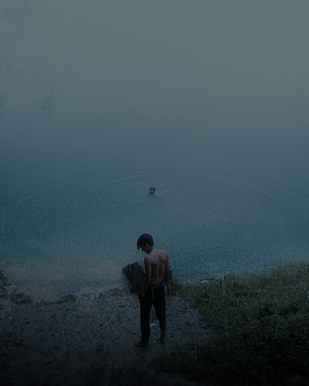 a man standing on a path next to a body of water