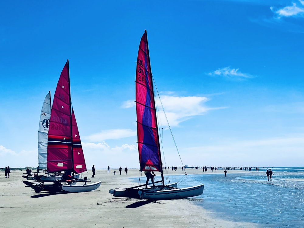 a couple of sail boats sitting on top of a beach