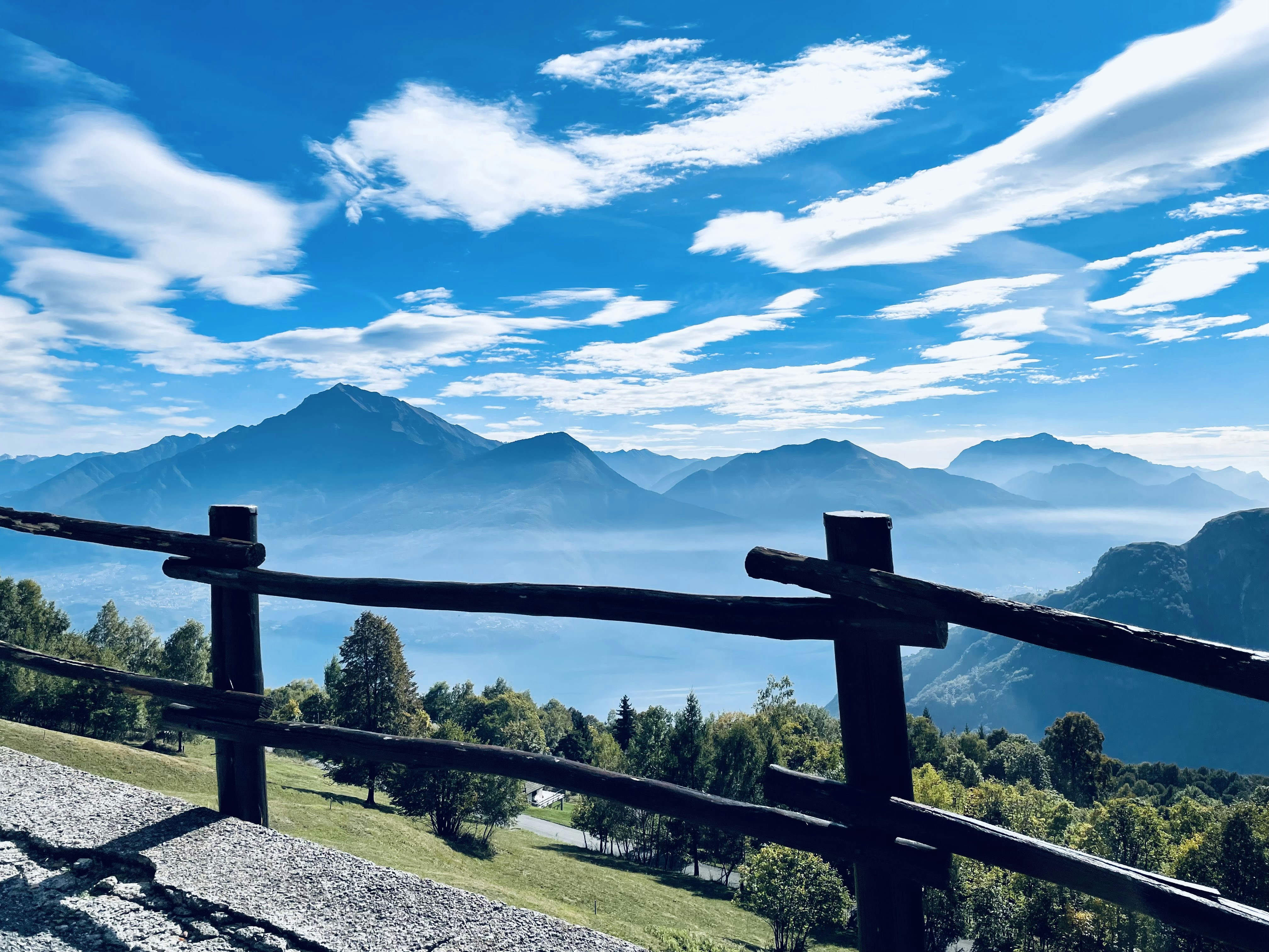 a view of a mountain range from a wooden fence