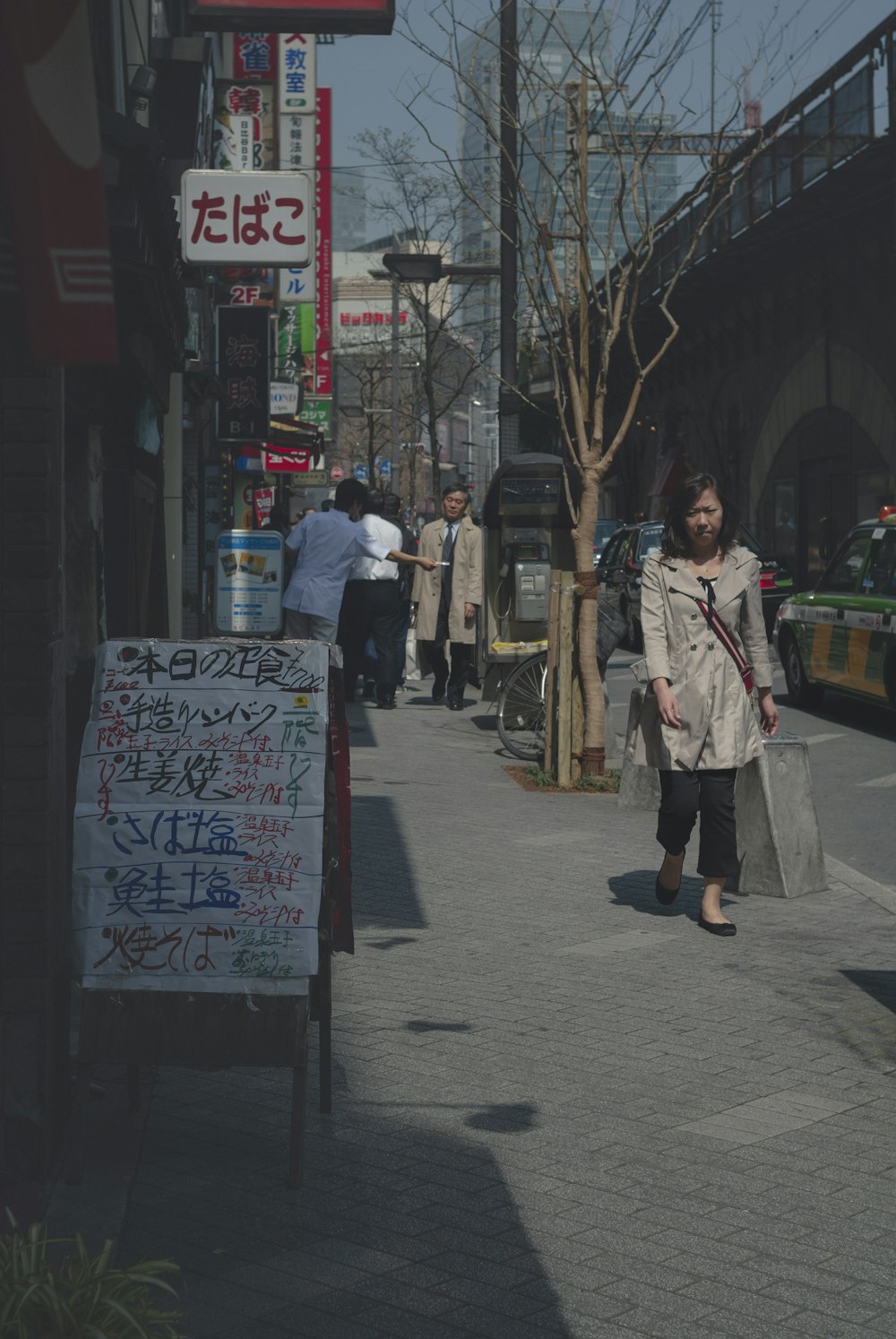 uma mulher andando por uma rua segurando sacolas de compras