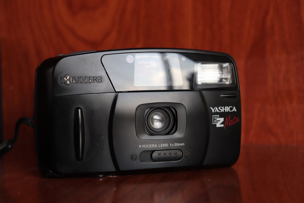 a black camera sitting on top of a wooden table