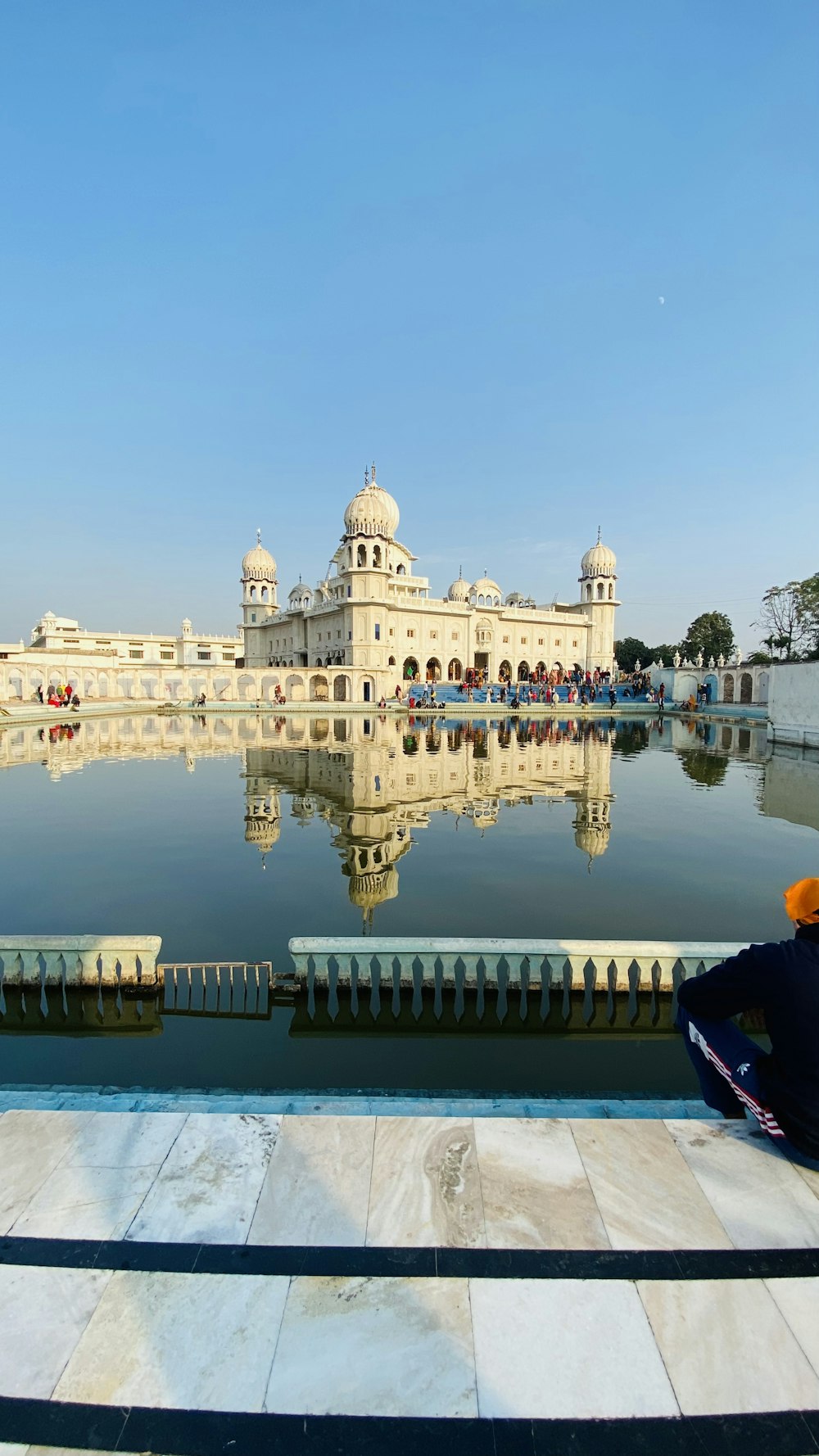 a man sitting on a bench looking at the water