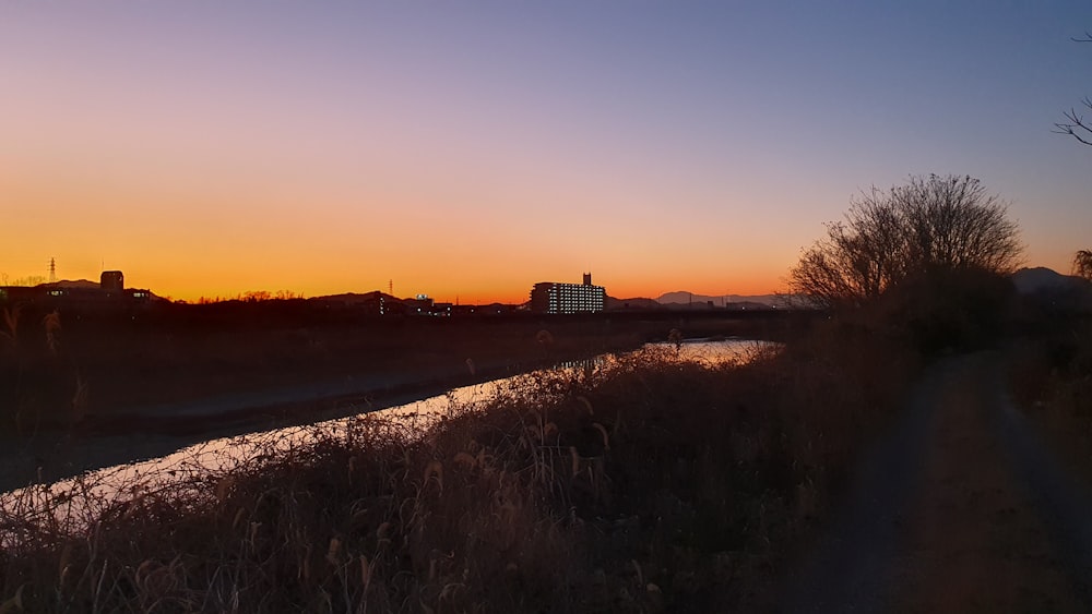 the sun is setting over a small river