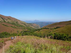 A cheerful group of travelers enjoying a scenic UK countryside tour with rolling hills and historic landmarks.