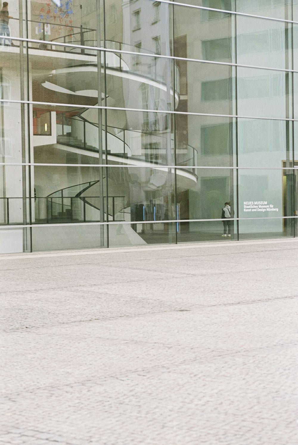 a man riding a skateboard down a street next to a tall building