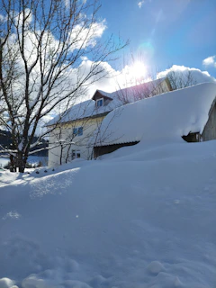 A cozy Canadian-style house with snow gently resting on the roof under a clear blue sky.