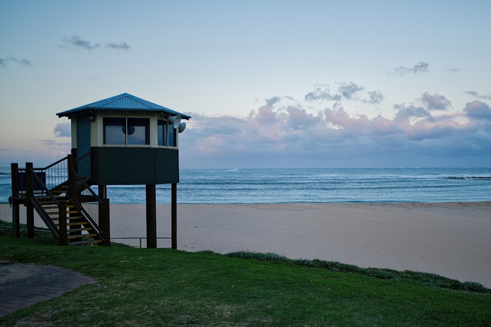 a lifeguard tower sitting on top of a beach next to the ocean