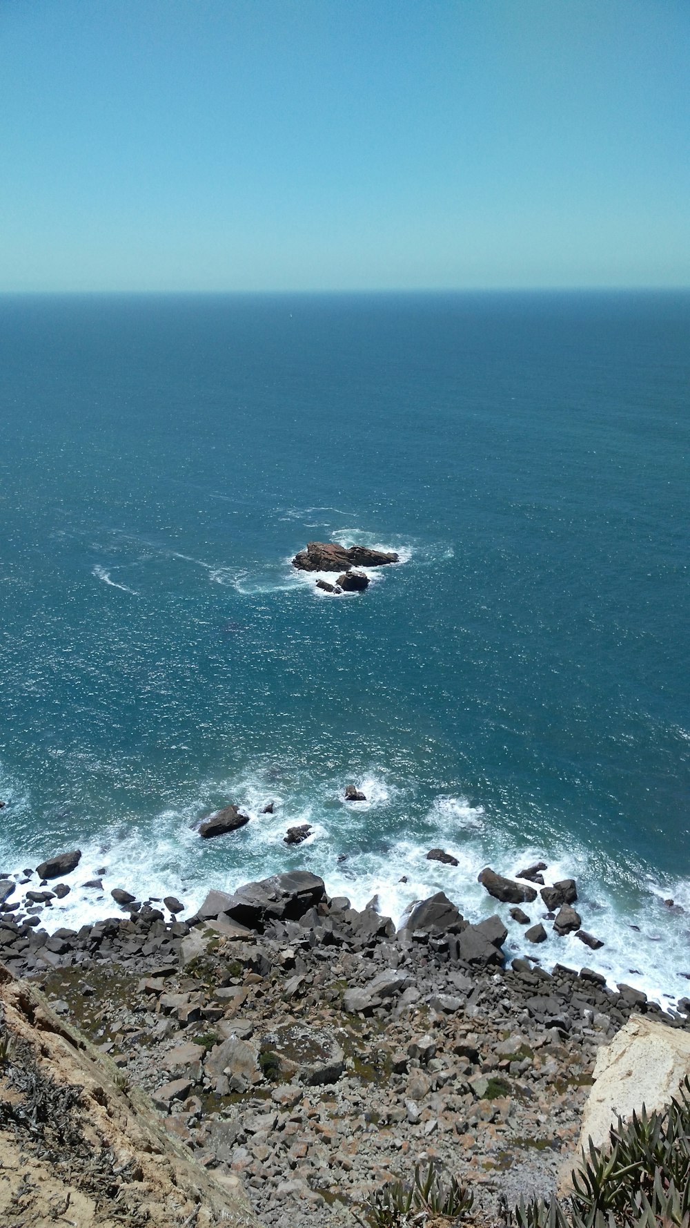 une vue d’un plan d’eau avec des rochers au premier plan