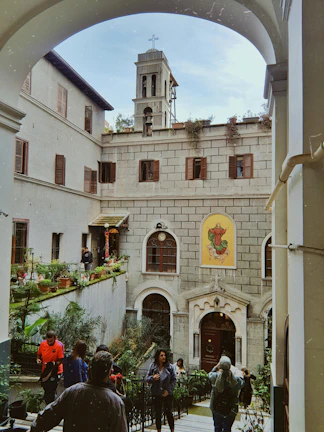 Pilgrims sharing smiles and stories in a peaceful courtyard.