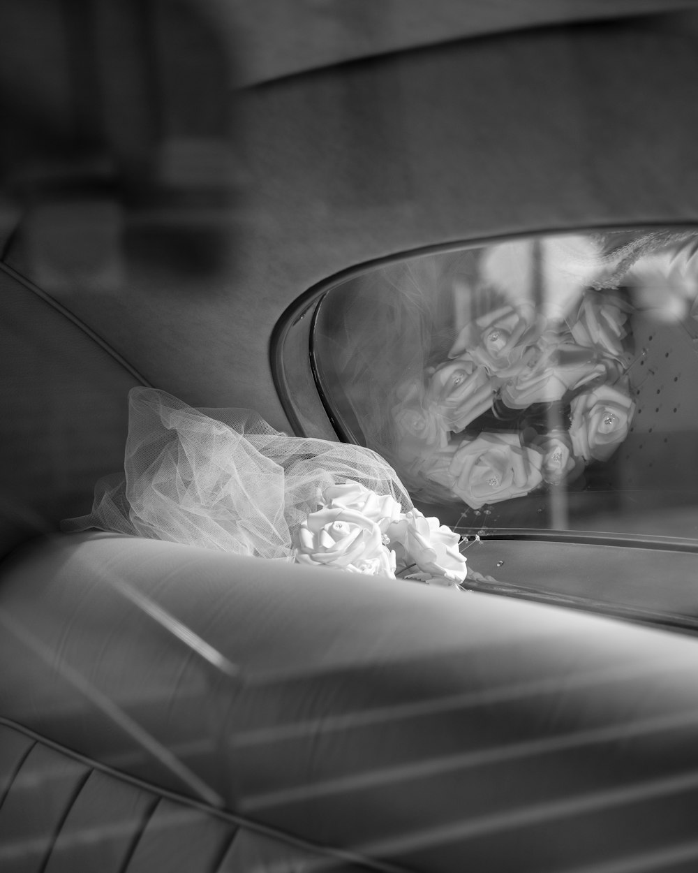 a black and white photo of a car's rear view mirror