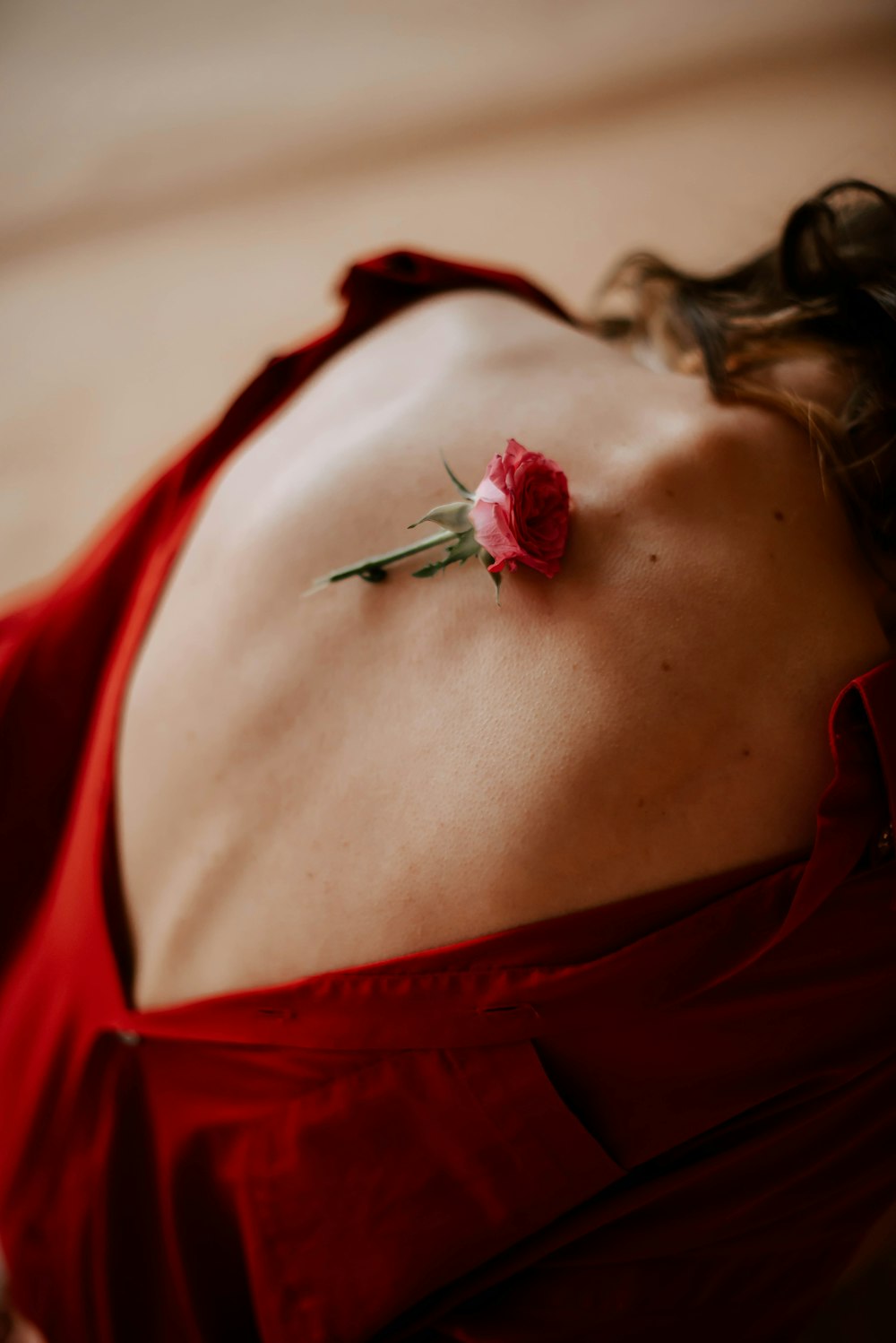 a woman in a red dress with a flower on her back