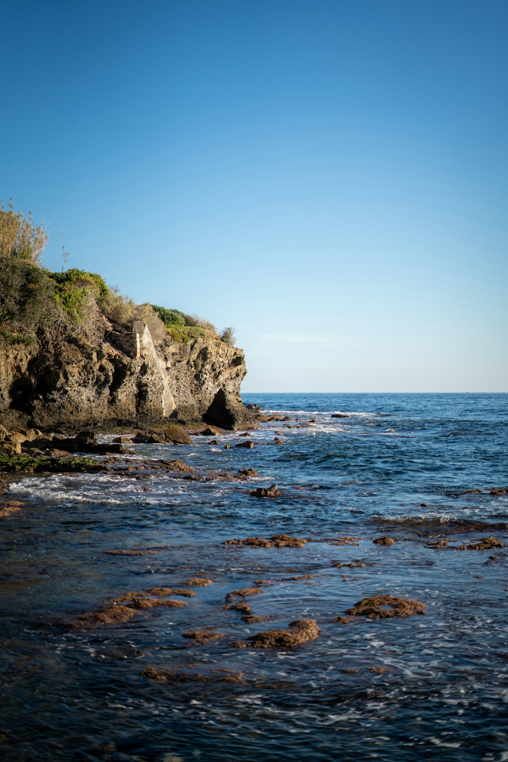 a large body of water sitting next to a rocky shore