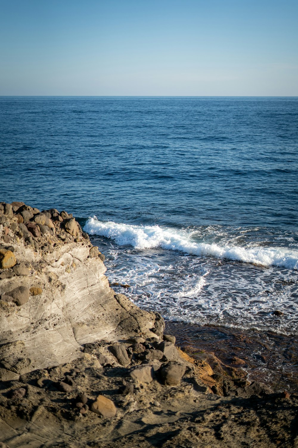 a view of the ocean from a rocky shore