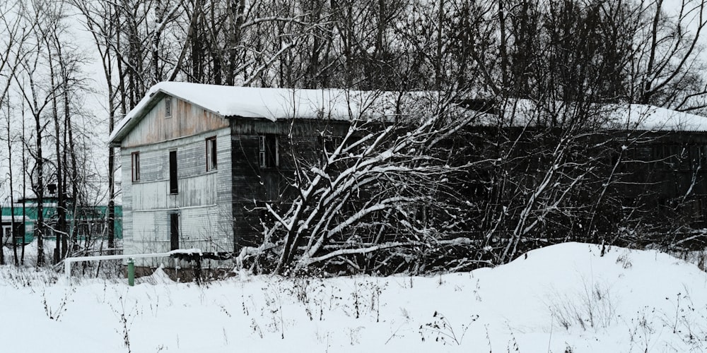 an old building in the middle of a snowy field