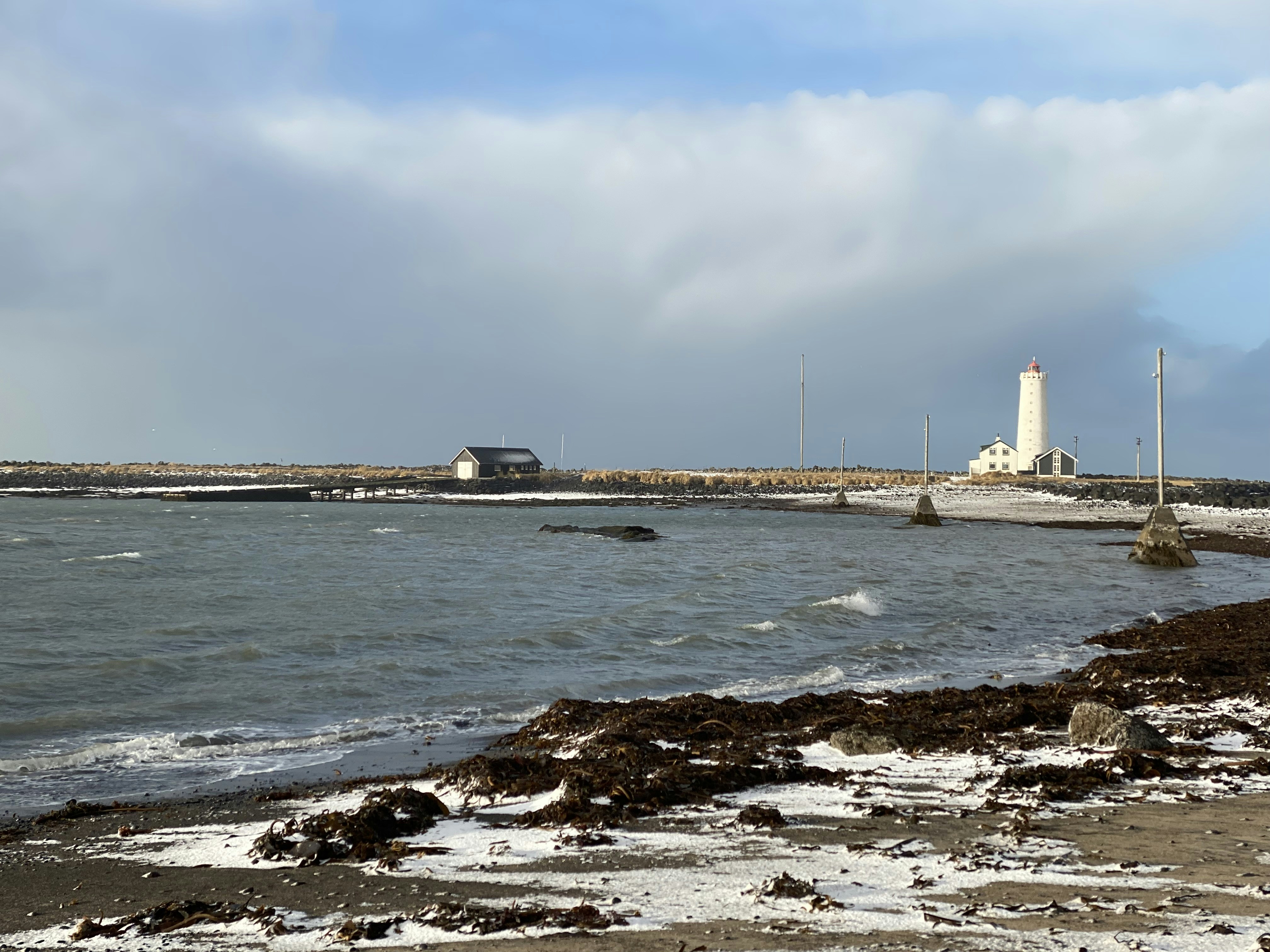 a body of water with a lighthouse in the background