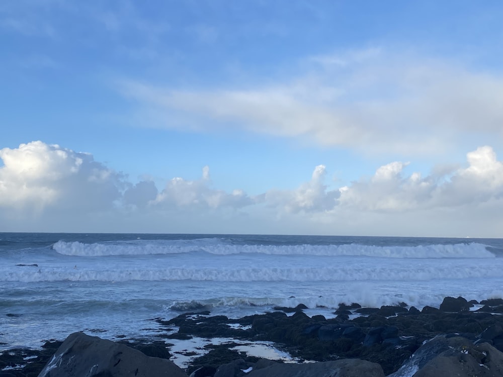 a large body of water sitting next to a rocky shore