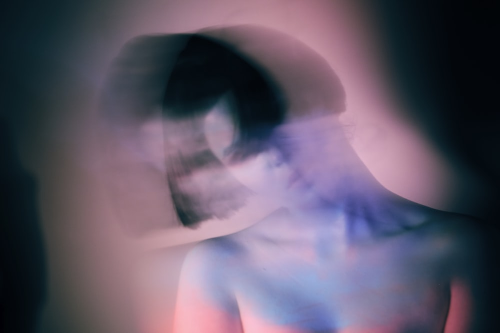 a blurry image of a woman with a hat on her head