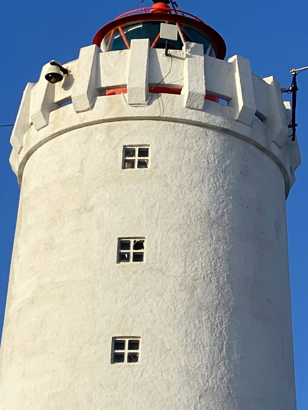 a tall white tower with a red top