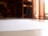 A close-up view of a blank white paper on a reflective surface, with a blurred background that includes shelves and warm lighting.