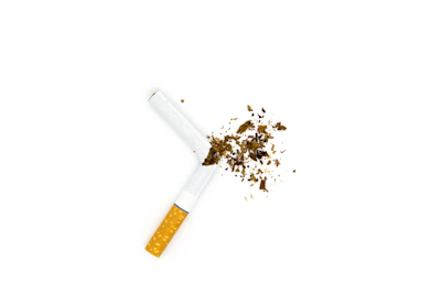 A confident person breaking a cigarette in half, symbolizing control over smoking addiction.