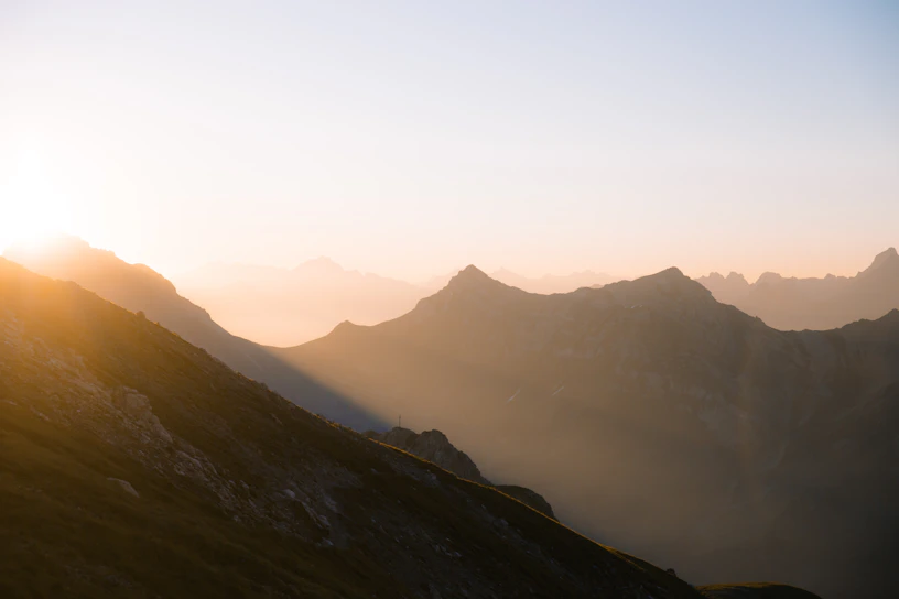 A serene Himalayan mountain sunrise with soft cosmic light hues blending into deep indigo skies.