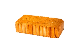 A rectangular red brick with a textured surface and visible sedimentary layers is displayed against a white background.