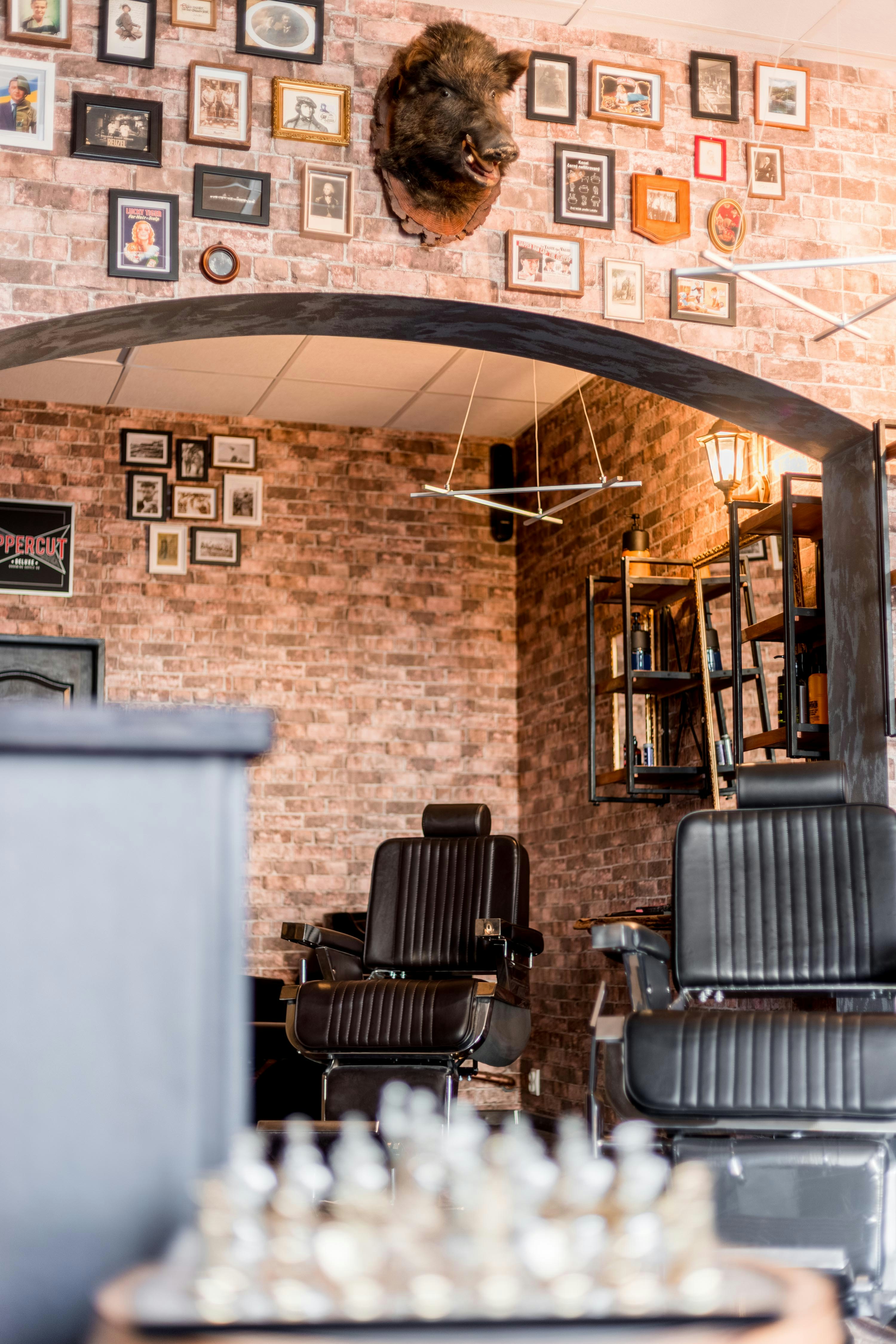 a barber shop with a brick wall and chairs
