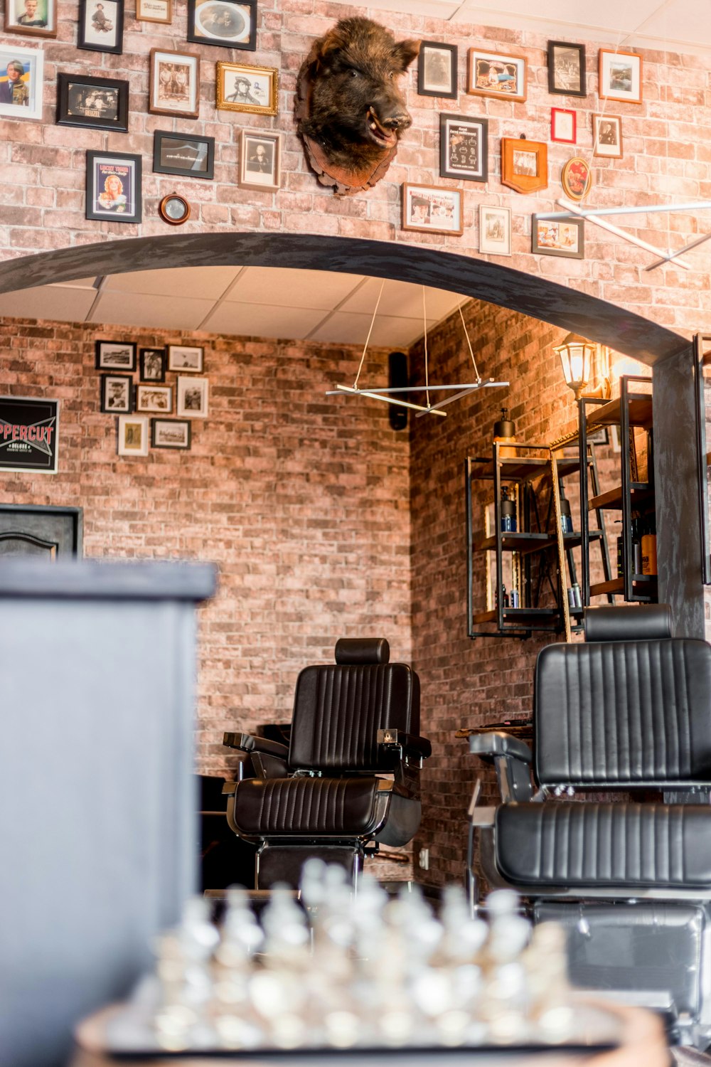 a barber shop with a brick wall and chairs